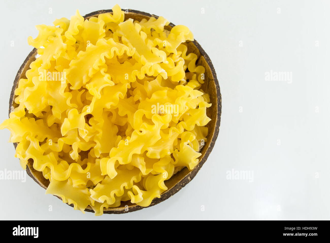 Pâtes farfalle papillon non cuits dans un bol on white Banque D'Images