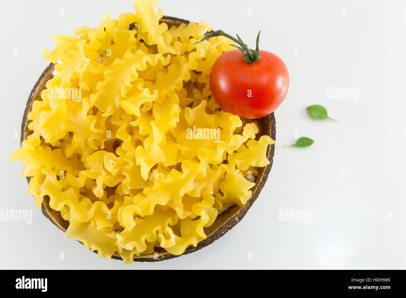 Pâtes farfalle papillon non cuits dans un bol on white Banque D'Images