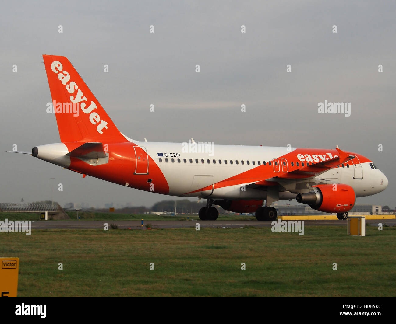 *G-EZFI* est un avion commercial d’easyJet qui roule au sol après avoir atterri sur la piste 18R à un aéroport non divulgué. La décoration orange distinctive de l'avion est une signature de la flotte d'easyJet. Banque D'Images