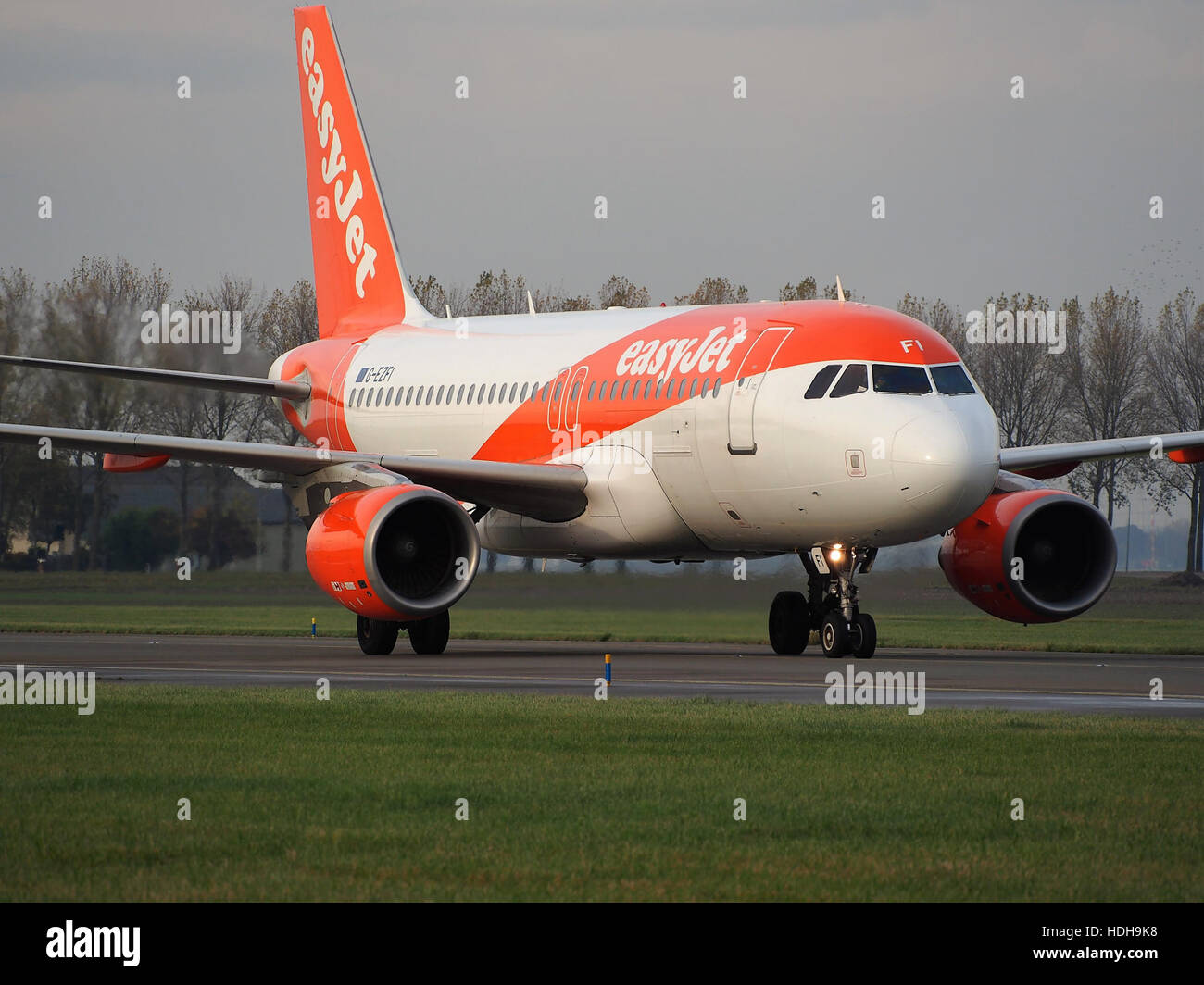 Le G-EZFI, un Airbus A320, est vu en train de rouler après avoir atterri sur la piste 18R. L'avion, immatriculé au Royaume-Uni, fait partie de la flotte exploitée par easyJet, une compagnie aérienne low-cost populaire. Cette image capture la phase post-atterrissage lorsque l'avion se déplace vers la porte d'embarquement d'un terminal d'aéroport. Banque D'Images
