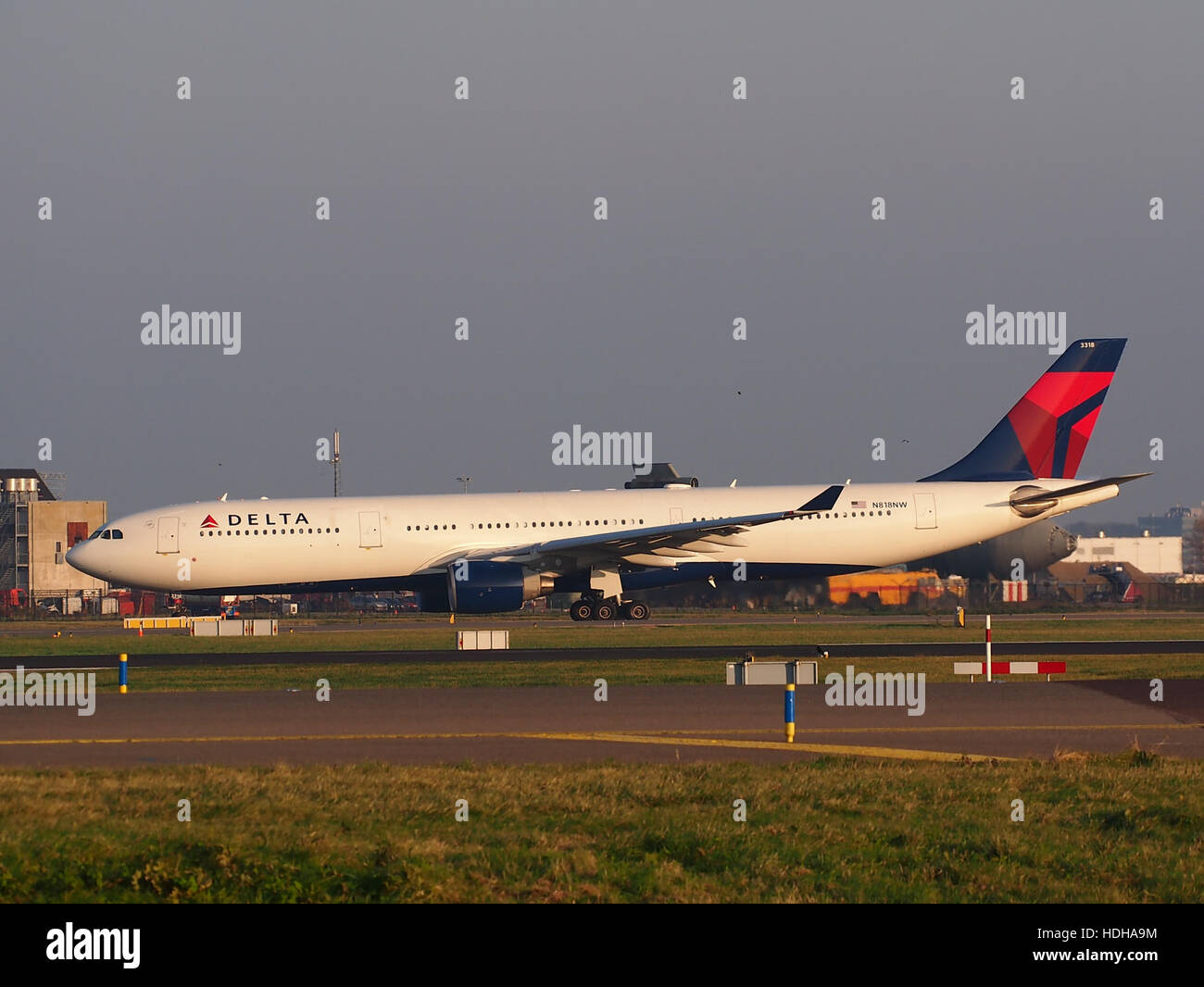 L'Airbus A330-323, immatriculé N818NW, exploité par Delta Air Lines, est capturé en traversant l'autoroute A5 à l'aéroport de Schiphol, aux pays-Bas, alors qu'il se prépare au décollage vers la piste 36L. Cet avion gros-porteur est un élément clé de la flotte long-courrier de Delta. Banque D'Images