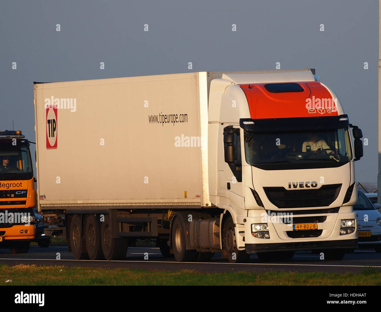 Cette image montre un camion Iveco de la flotte TIP circulant sur l'autoroute A5. La photographie capture l'échelle et la présence du camion, soulignant son rôle dans la logistique et le transport. IVECO est un fabricant bien connu de véhicules utilitaires, et TIP est un opérateur de flotte de premier plan. Banque D'Images
