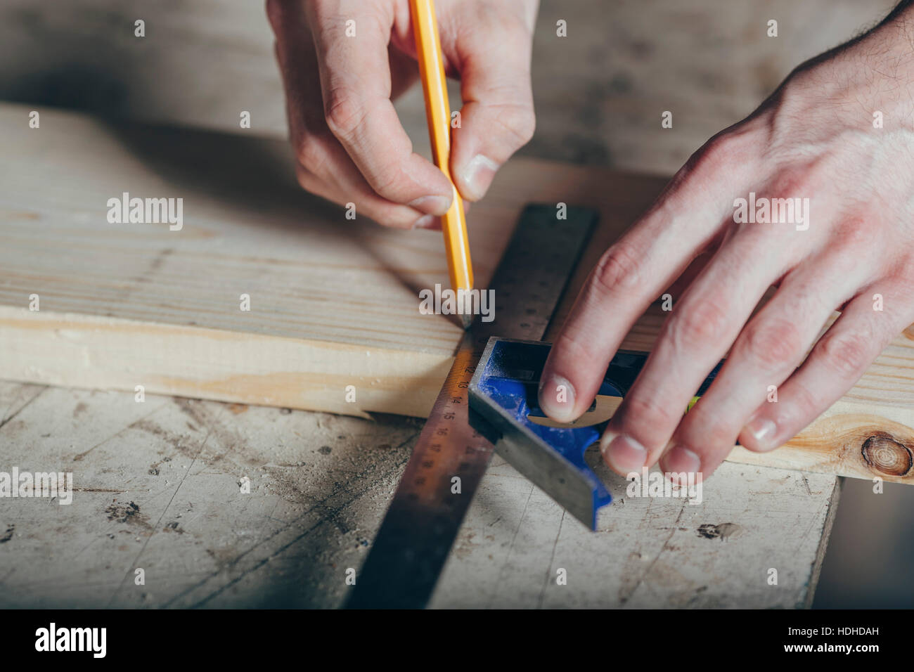 Les mains coupées de carpenter marquage sur plank avec crayon et règle à l'atelier Banque D'Images