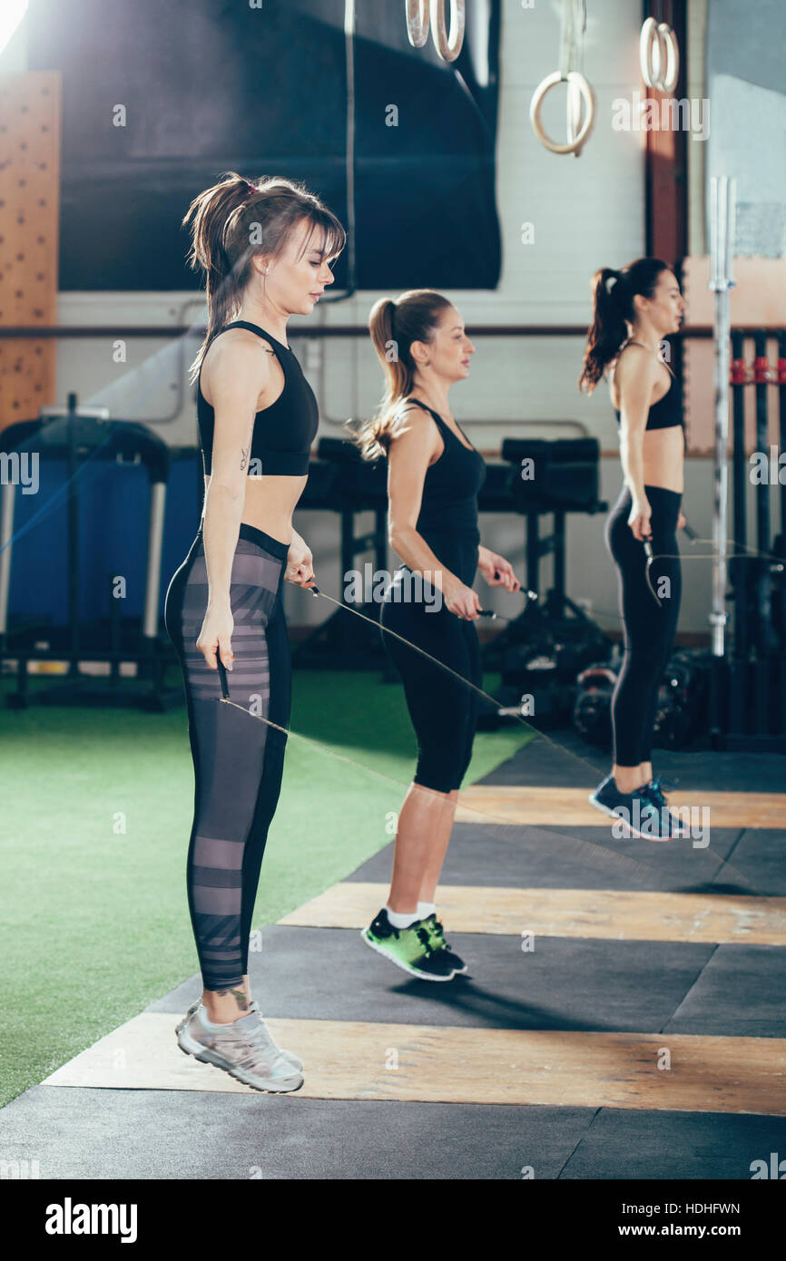 Vue latérale des athlètes femmes exerçant avec des cordes à sauter de fitness Banque D'Images