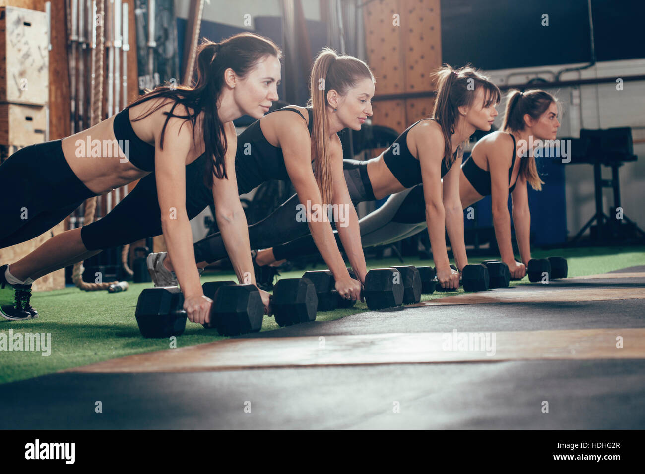 Les athlètes déterminés de faire des tractions sur les haltères au club de santé Banque D'Images