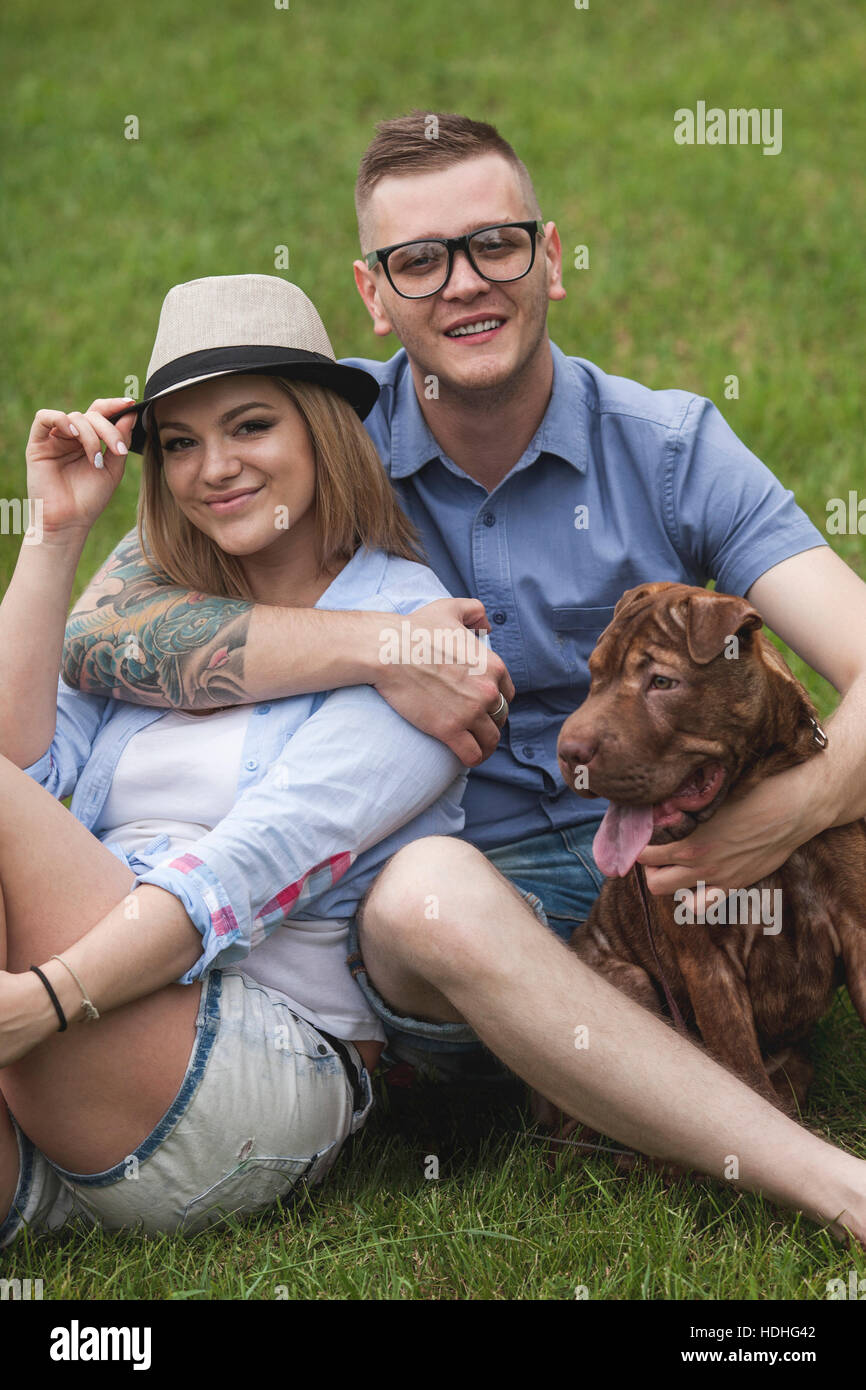 Un couple avec leur Shar-pei/Staffordshire Terrier chien dans le parc Banque D'Images