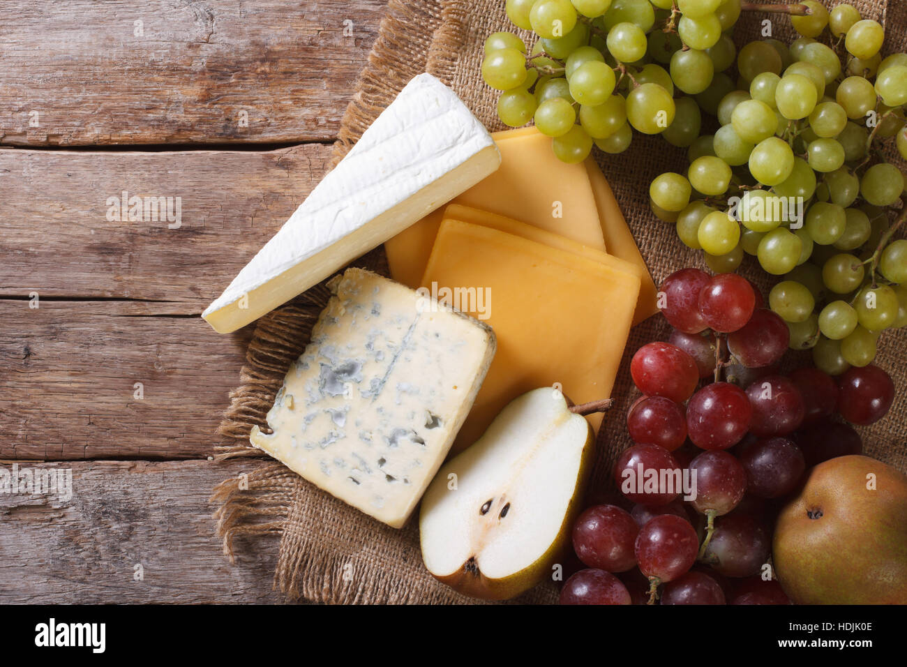 Raisins verts et rouges, poires et fromage sur la table horizontale vue du dessus. Banque D'Images