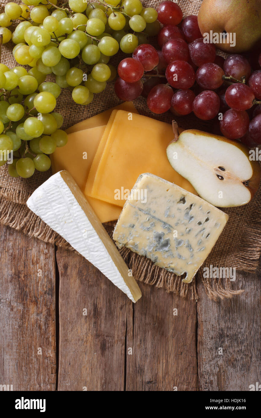 Raisins verts et rouges, poires et fromage sur la table. vertical Vue de dessus Banque D'Images