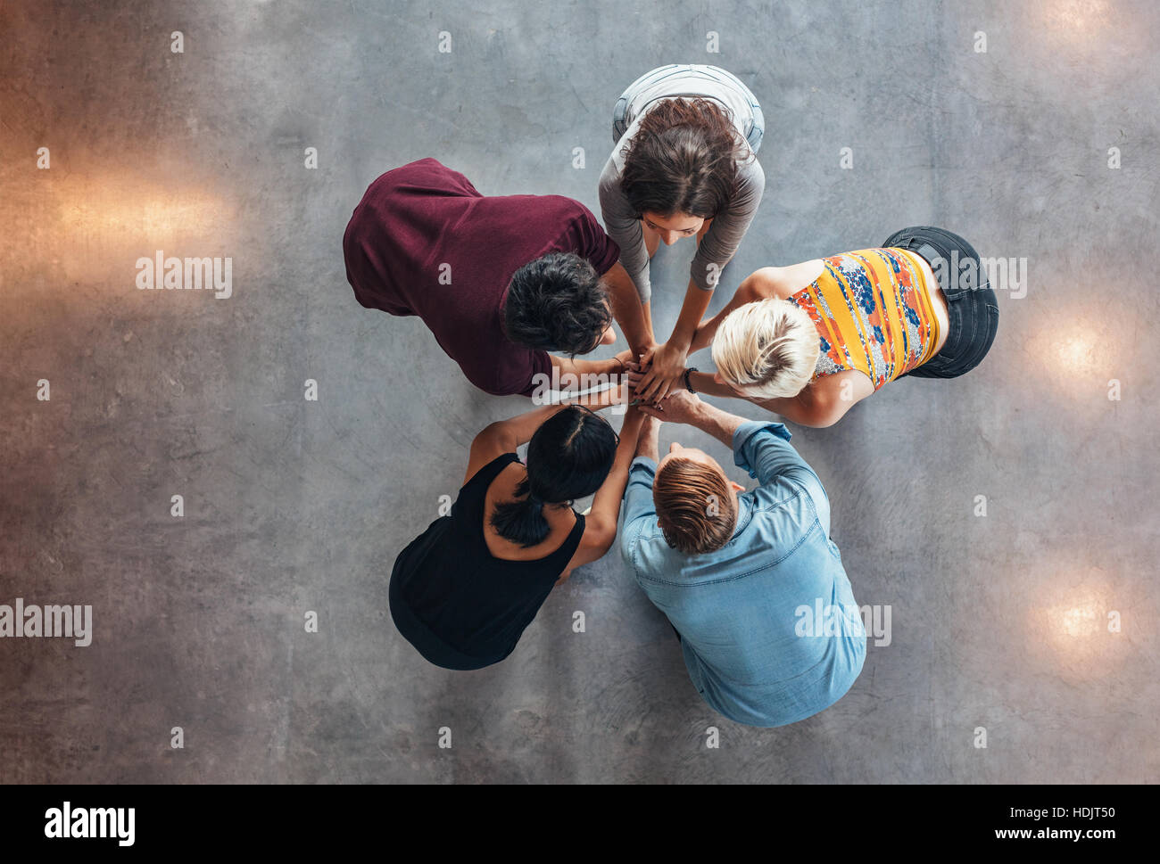 Vue de dessus du groupe de jeunes de mettre leurs mains ensemble. Les jeunes élèves debout dans un cercle faisant pile de mains montrant le succès. Banque D'Images