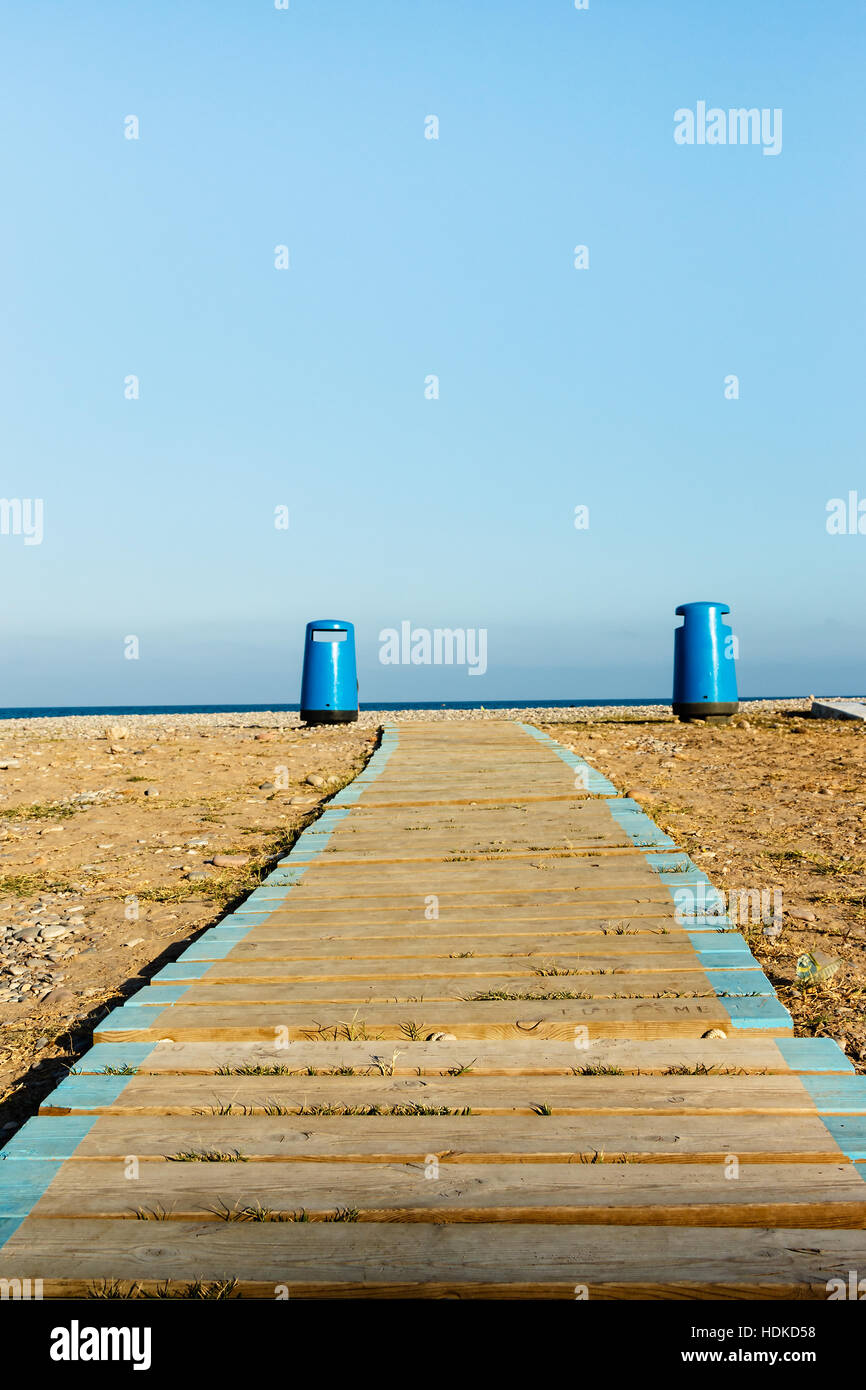 Passerelle en bois sur la plage avec deux corbeilles en arrière-plan. Vertical image. Banque D'Images