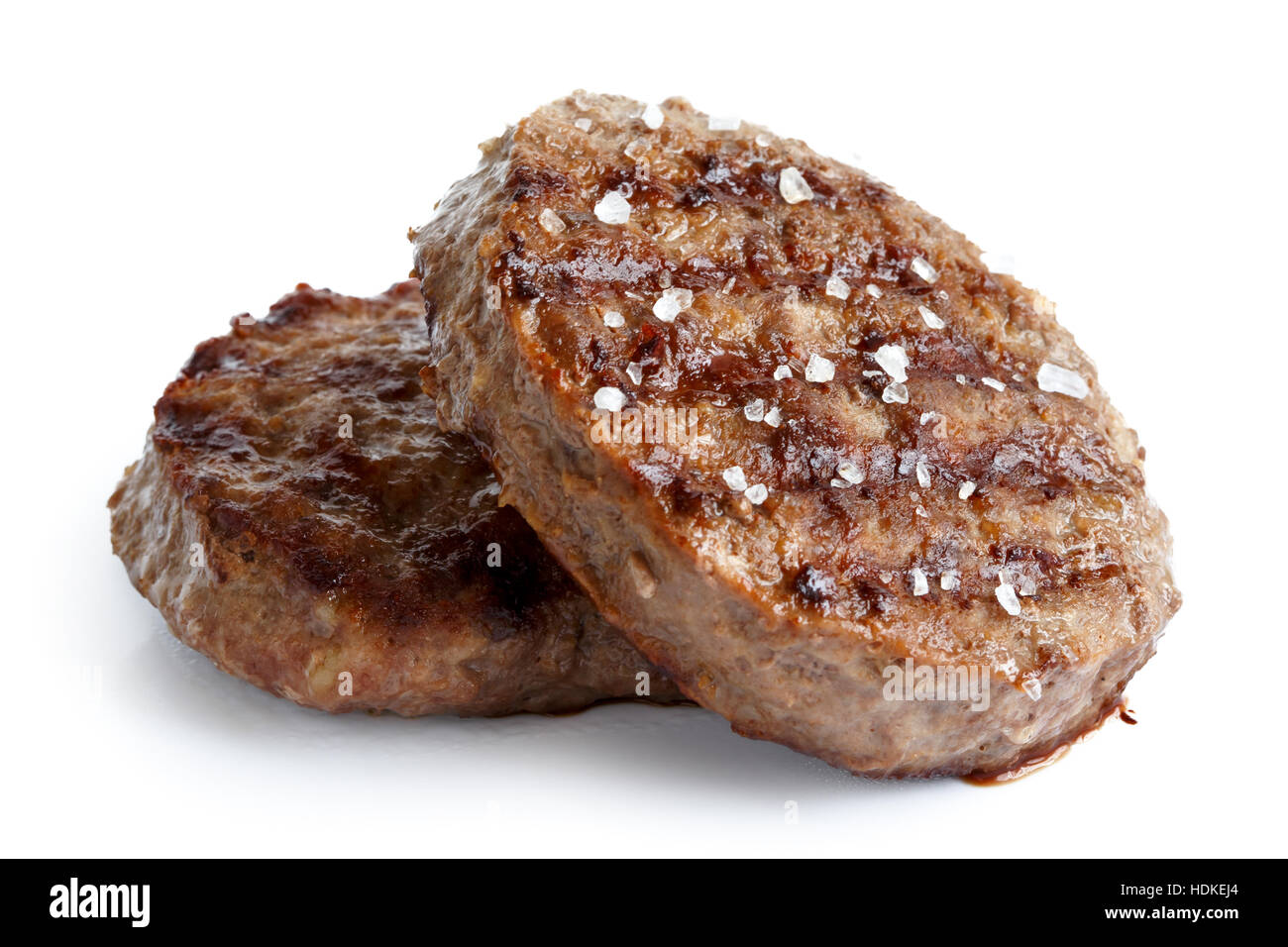 Deux pâtés de bœuf grillé avec du sel isolé sur blanc. Banque D'Images