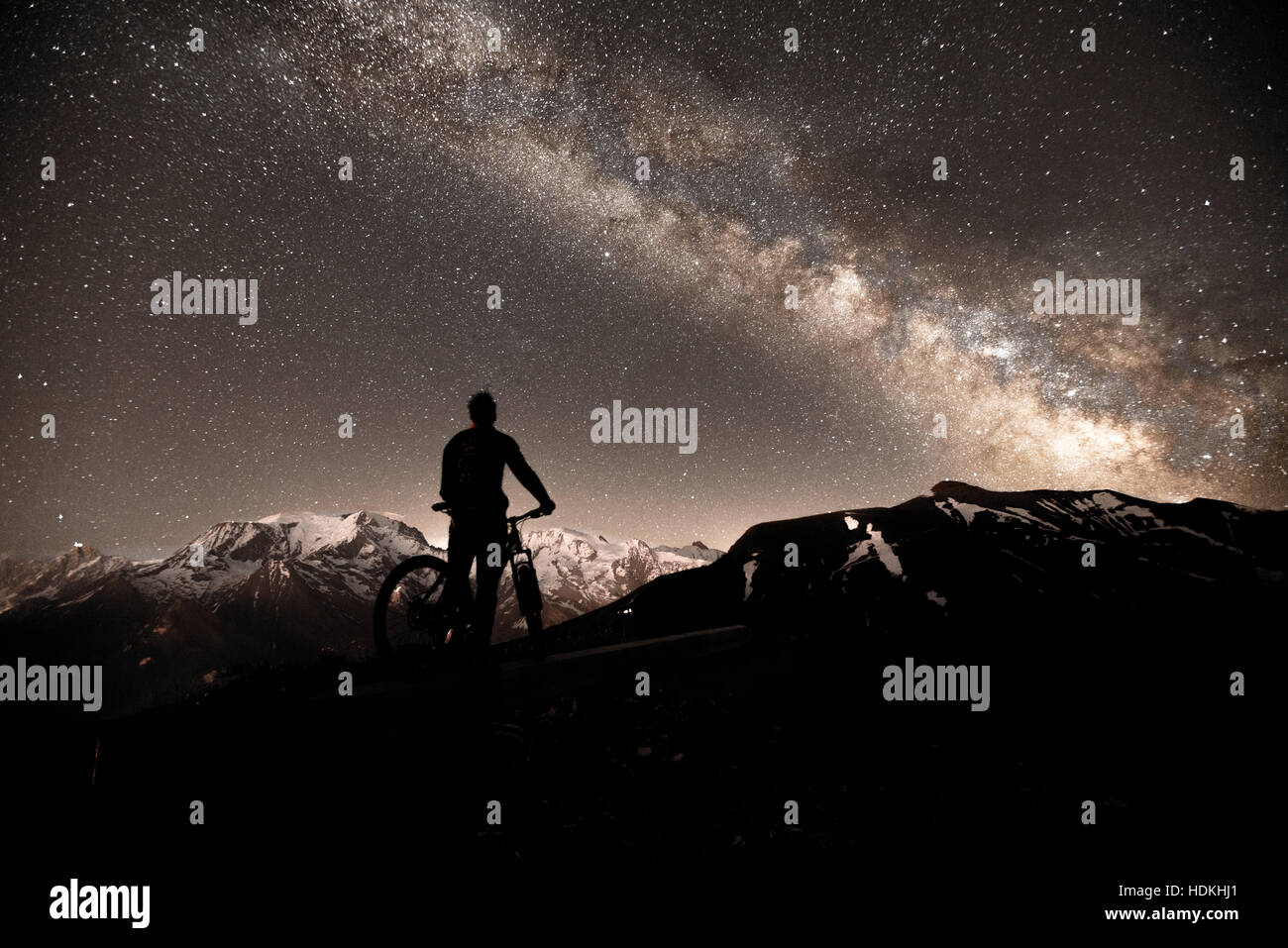 Voie lactée. Ciel de nuit avec des étoiles et silhouette d'un homme avec le vélo Banque D'Images