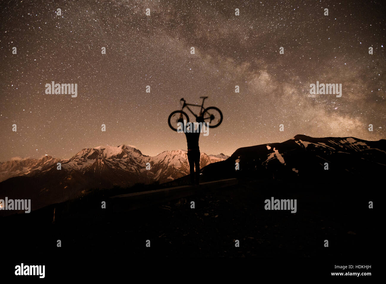 Voie lactée. Ciel de nuit avec des étoiles et silhouette d'un homme avec le vélo Banque D'Images