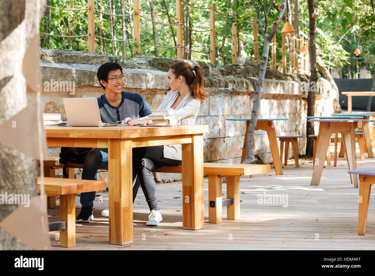 Cheerful young couple d'étudiants usng laptop in cafe ensemble Banque D'Images