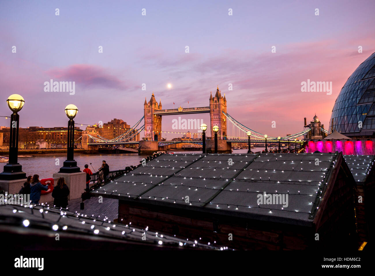 London Tower Bridge à une belle soirée de pleine lune avec marché de Noël chalets avec des lumières à l'avant-plan. Banque D'Images