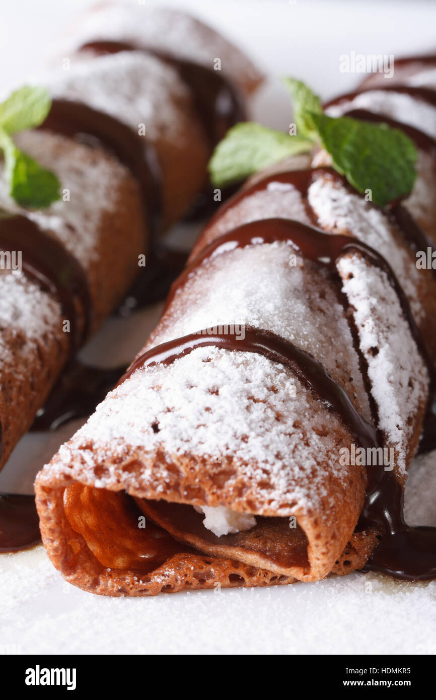 Des crêpes au chocolat avec sauce à la menthe et macro sur une plaque verticale. Banque D'Images