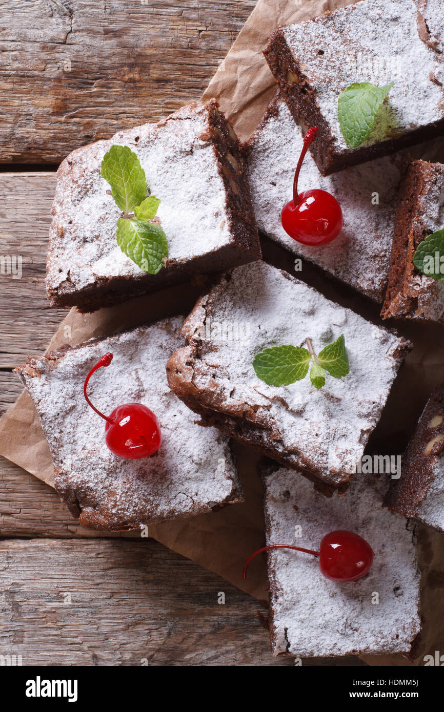 Brownie cake à la menthe et cerise sur papier. Vue verticale de ci-dessus, style rustique Banque D'Images