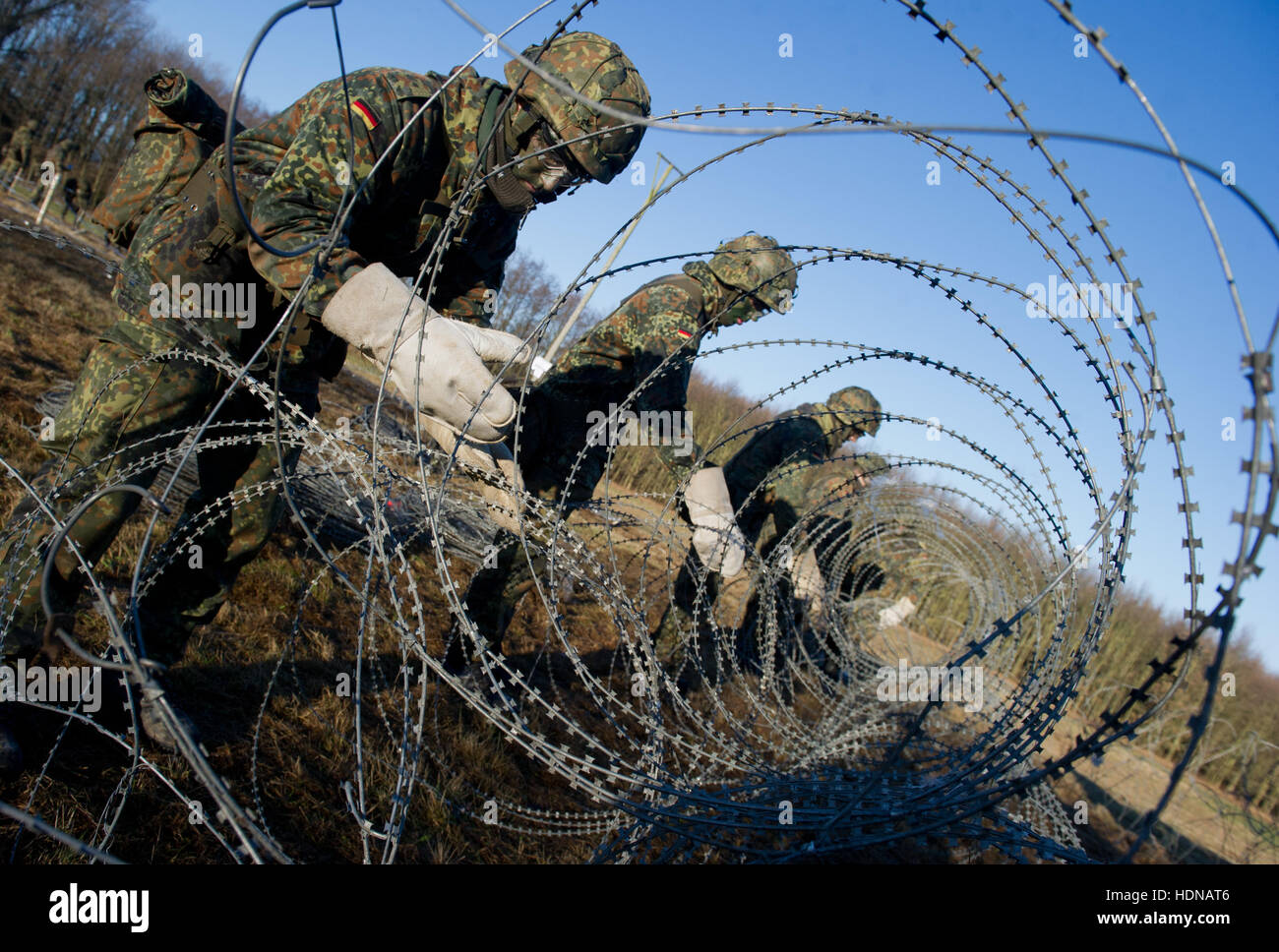 Des soldats dans leur formation de base sont l'érection d'une clôture en fil barbelé sur les locaux de l'École technique de Marine Parow près de Stralsund, Allemagne, 14 décembre 2016. Le budget annuel pour la recherche de jeunes recrues des mesures à 35 millions d'euros cinq ans après l'abolition du service militaire obligatoire. L'armée allemande a rejeté les critiques concernant leur nouvelle websérie YouTube, un reality show appelé 'Les recrues', disant qu'ils étaient d'en minimiser l'horreur et la violence de l'engagement militaire. Selon l'armée allemande, les séries ont été censés capturer la formation de recr Banque D'Images