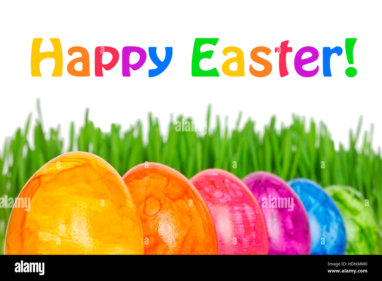 Rangée de 6 oeufs de Pâques colorés en face de Green grass, texte Joyeuses Pâques, dans des couleurs arc-en-ciel Banque D'Images