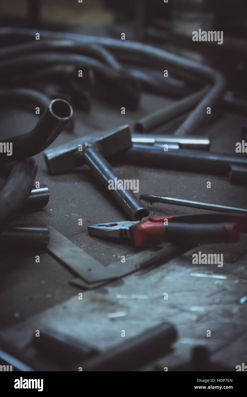 Tuyau et d'outils sur une surface de travail dans une entreprise de fabrication. Photo verticale. Banque D'Images