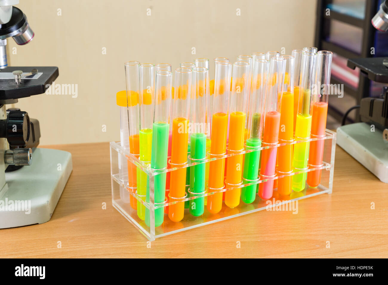 Divers liquides colorés dans des tubes à essai à côté de microscope Banque D'Images