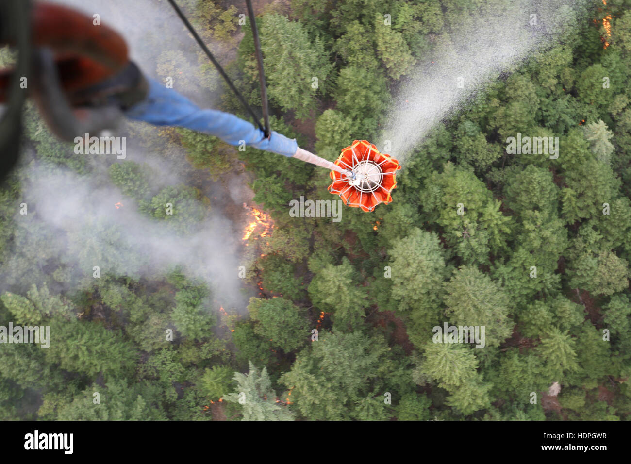 Les soldats de la Garde nationale des États-Unis d'éteindre un incendie avec de l'eau du comté de Shasta de Bambi benne montée sur un Boeing CH-47 Chinook hélicoptère gros porteur le 18 août 2015 à Redding en Californie. Banque D'Images
