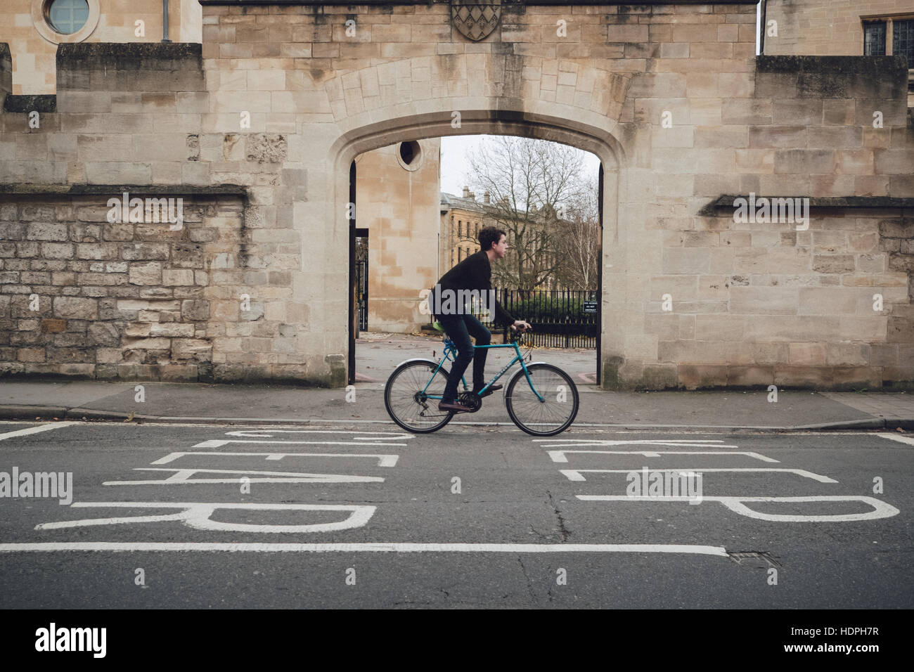 Un cycliste au cours de cycles d'un signe clair sur la route dans la ville universitaire d'Oxford au Royaume-Uni. Banque D'Images