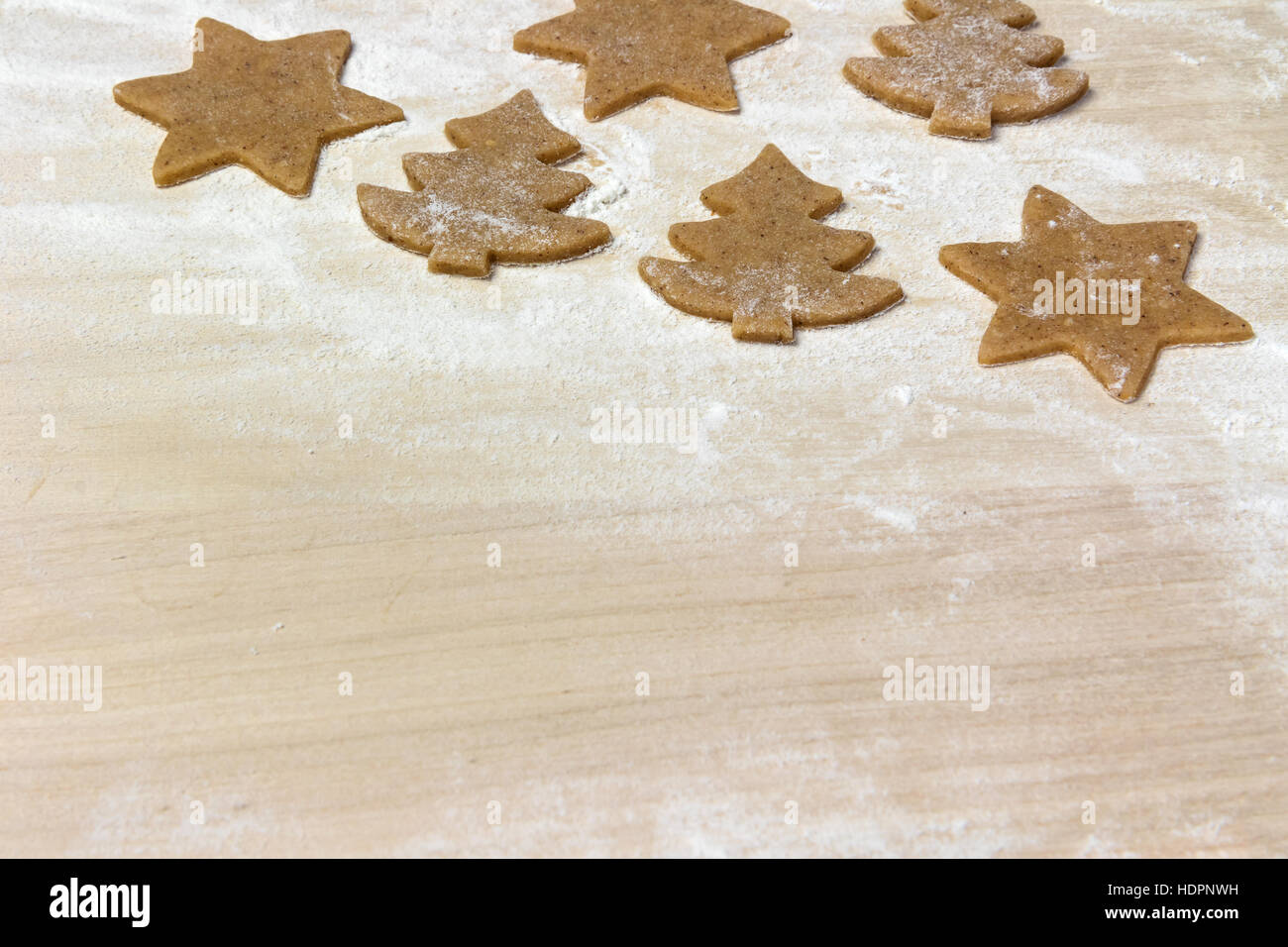 La cuisson de cookies de Noël - les formes découpées de cookies sur le bord en bois farinée. Place gratuite pour votre texte est dans la partie inférieure de la photo. Banque D'Images