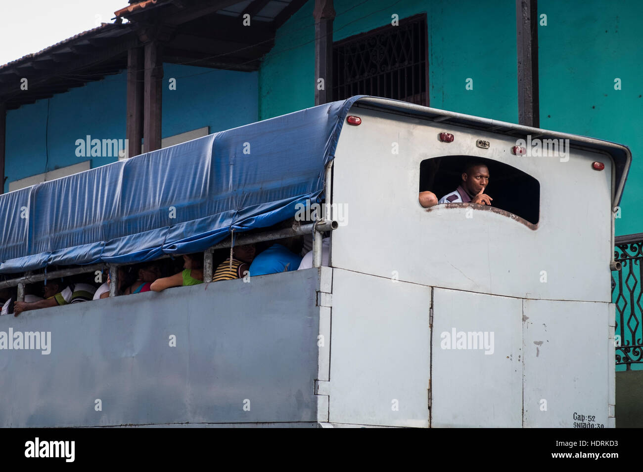 L'homme regardant par la fenêtre arrière d'un camion, bus, taxi, transports publics locaux à Santiago de Cuba, Cuba Banque D'Images