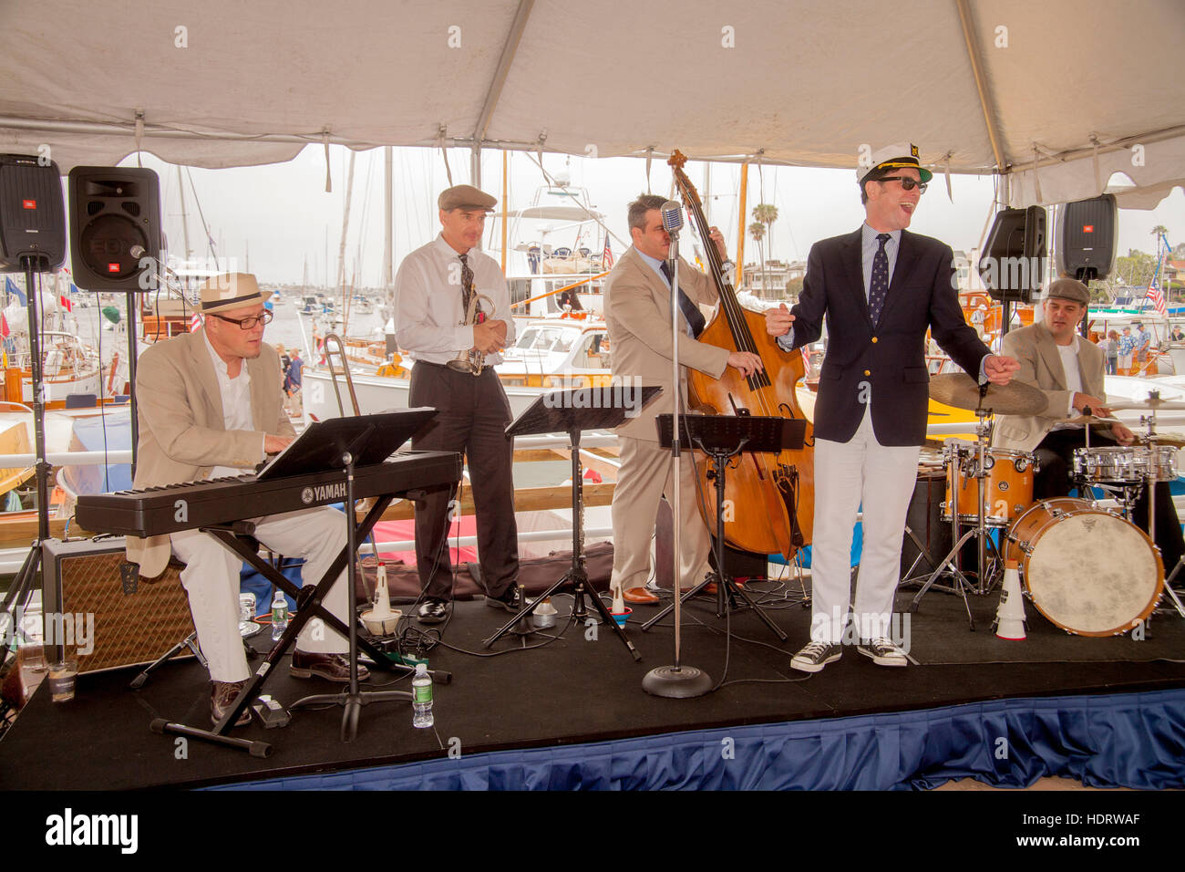 Son chanteur décoré dans un yachting cap, une bande de divertir les visiteurs à une exposition de vieux bateaux en bois dans une marina à Newport Beach, CA. Banque D'Images