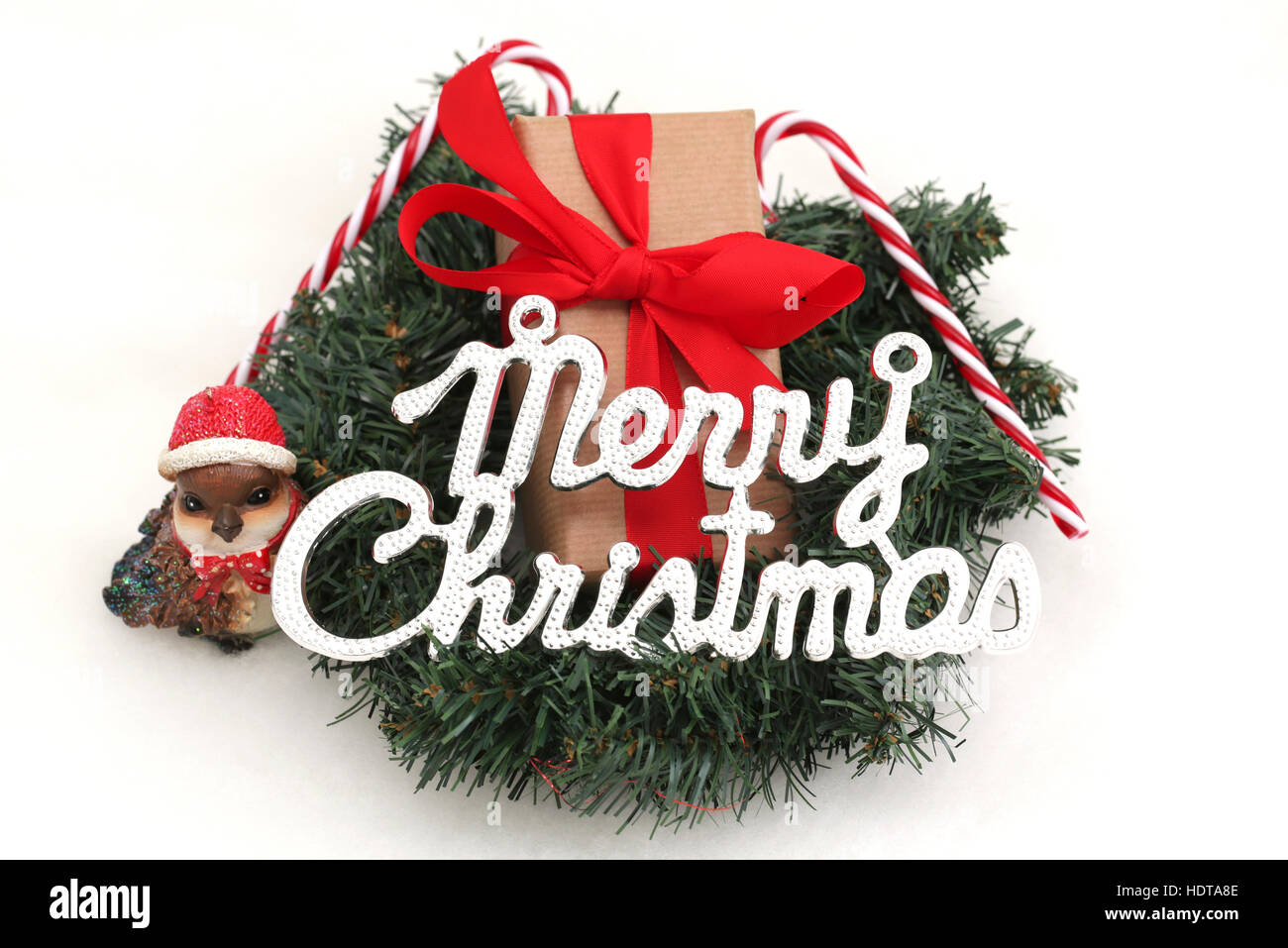 Un cadeau de Noël dans une couronne avec les décorations de Noël et le mot Joyeux Noël Banque D'Images