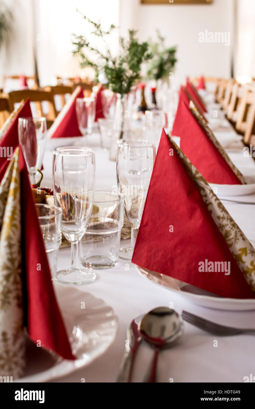 Cas table avec nappe blanche et rouge serviettes Banque D'Images