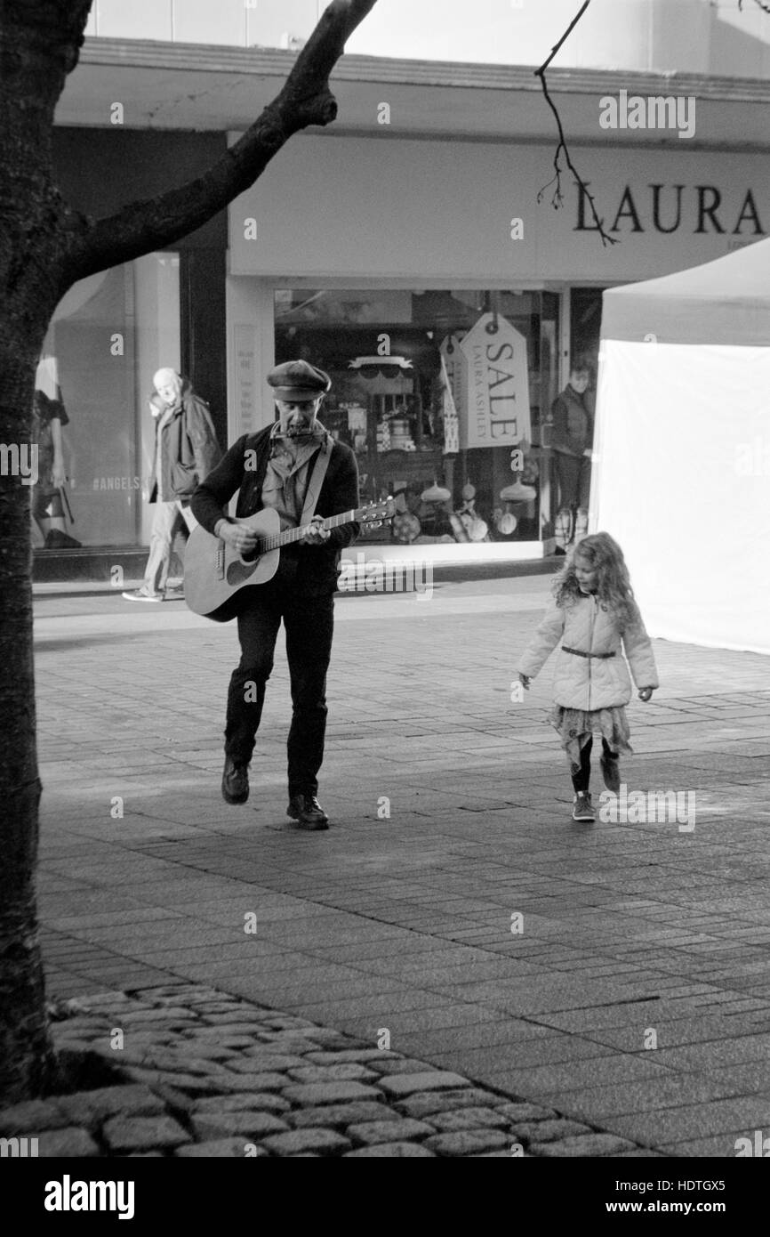 Une jeune fille danse avec un musicien ambulant de rue en Angleterre southsea Banque D'Images