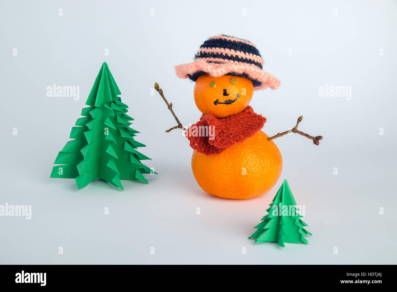 La figure de décoration de mandarins comme bonhomme hiver noël en style avec sapins sur fond blanc Banque D'Images