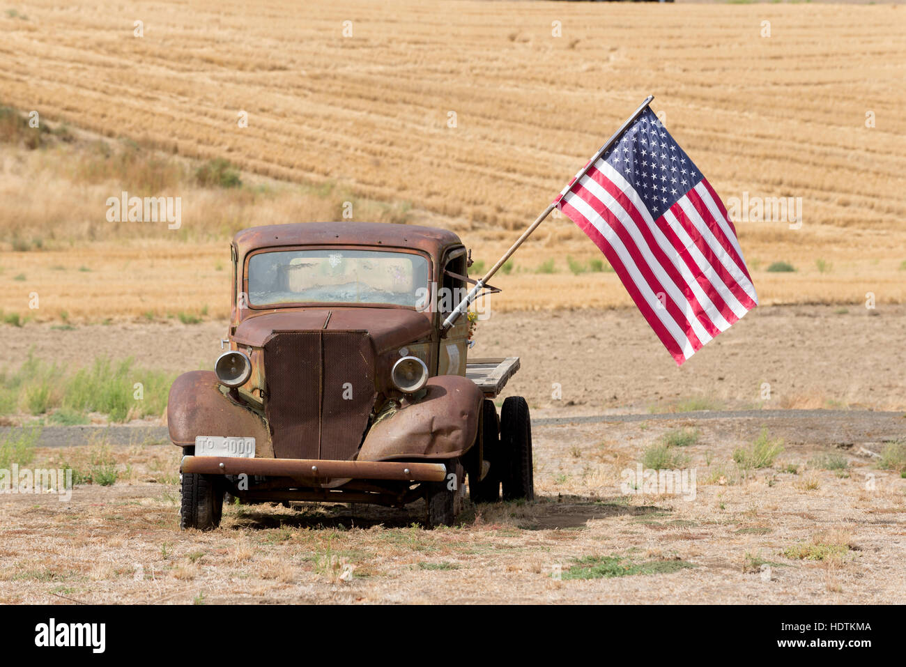 Vieille Ford camion à plateau avec un drapeau américain dans une ferme à l'Est de Washington. Banque D'Images
