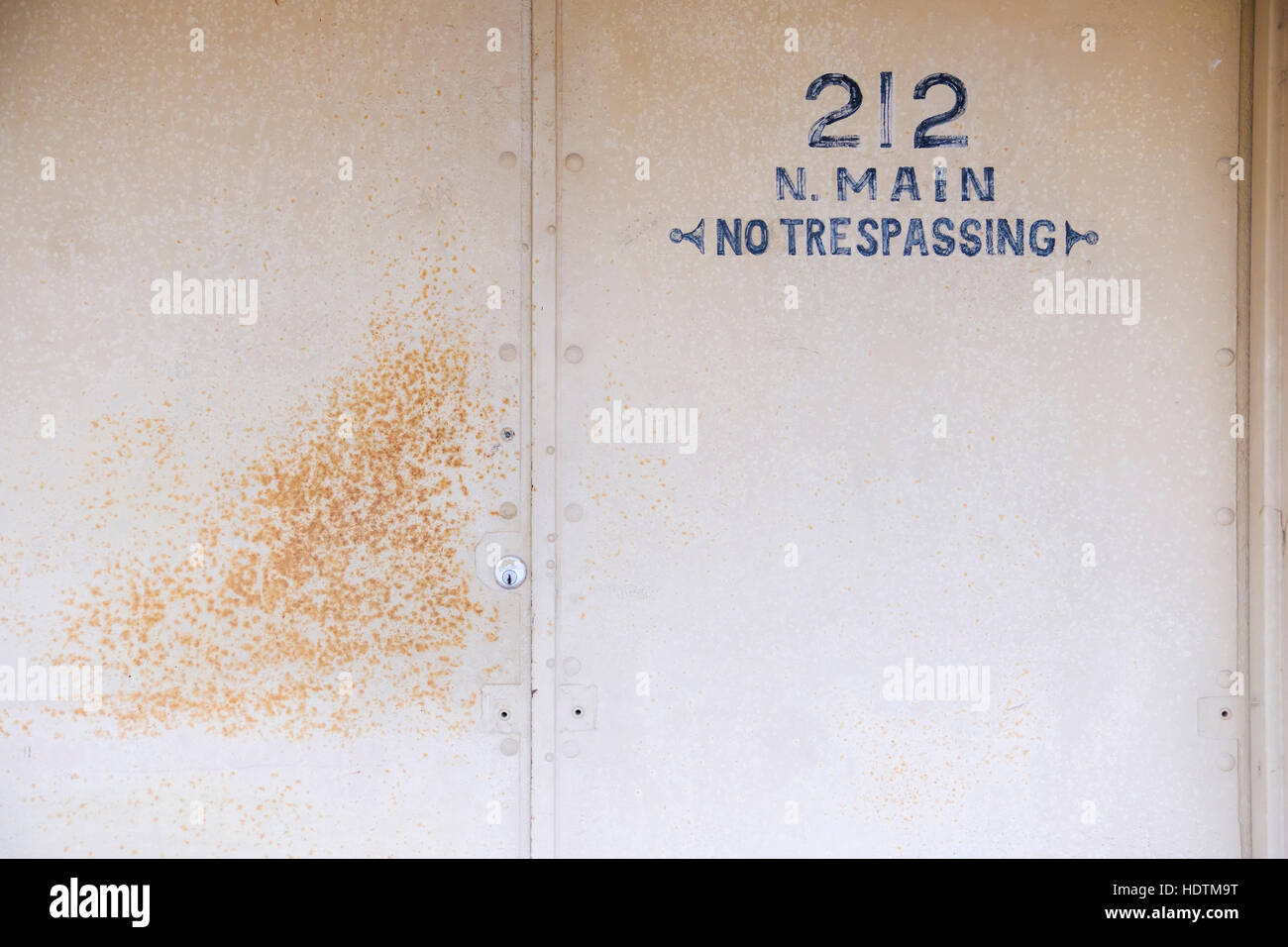 Une adresse avec un pochoir peint aucune intrusion signe sur une porte métallique. Concept standoffish. USA. Banque D'Images