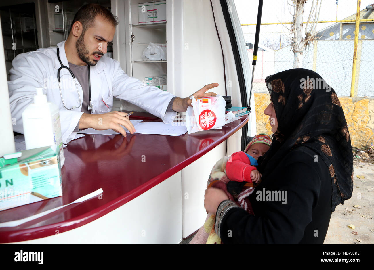 Un pharmacien qui sont les volontaires pour la clinique médicale mobile de Caritas distribue des médicaments aux réfugiés syriens dans un campement près de Taalabaya dans la vallée de la Bekaa. Banque D'Images