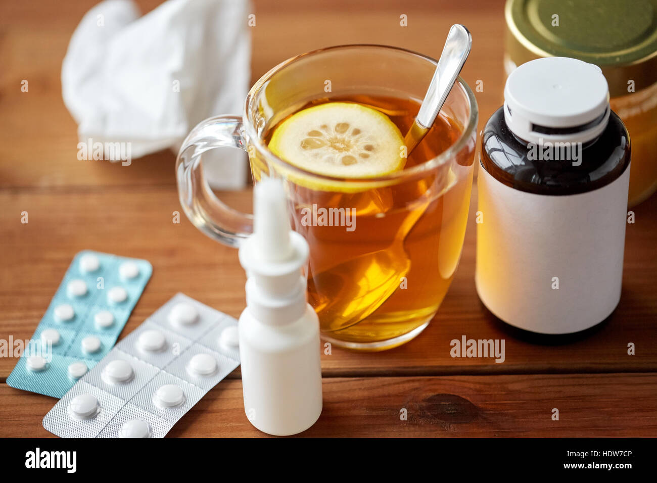 Tasse de thé, de drogues, de miel et de mouchoir en papier sur bois Banque D'Images