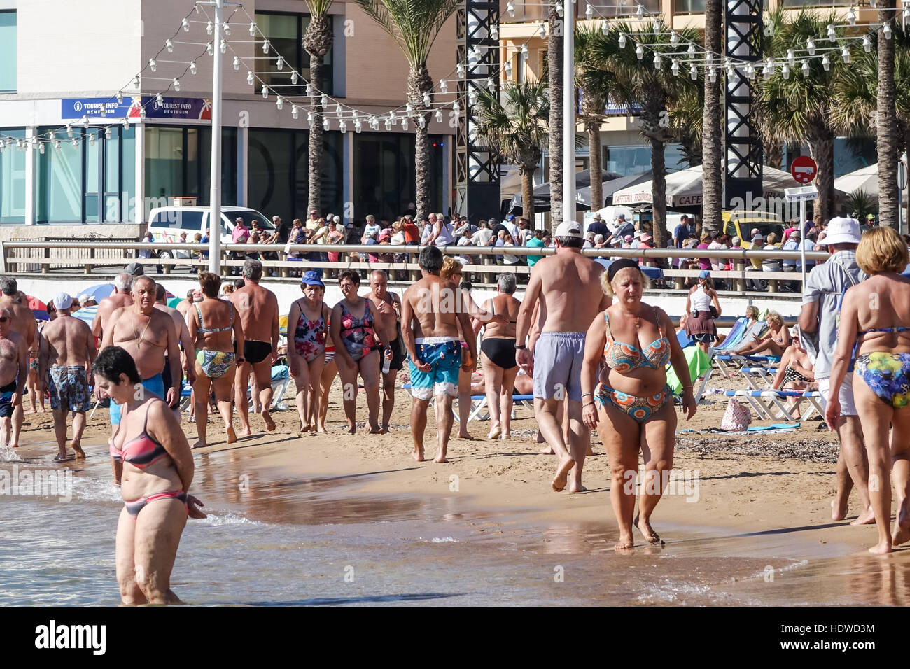 Scène de plage bondée avec principalement des personnes âgées, hommes et femmes, la marche de détente ou d'exercer sur le rivage Banque D'Images