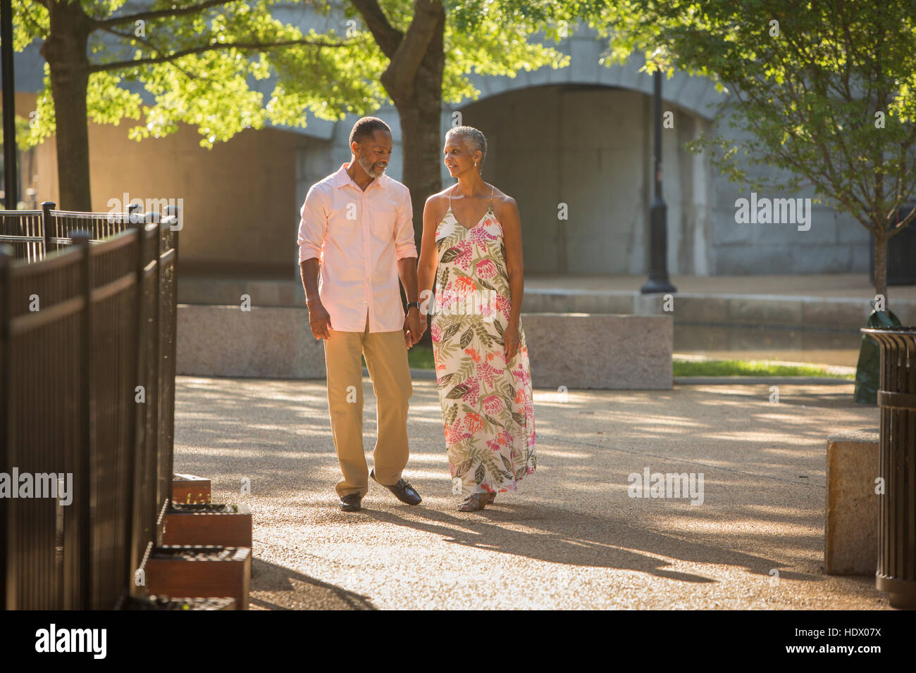 Black couple holding hands walking in park Banque D'Images