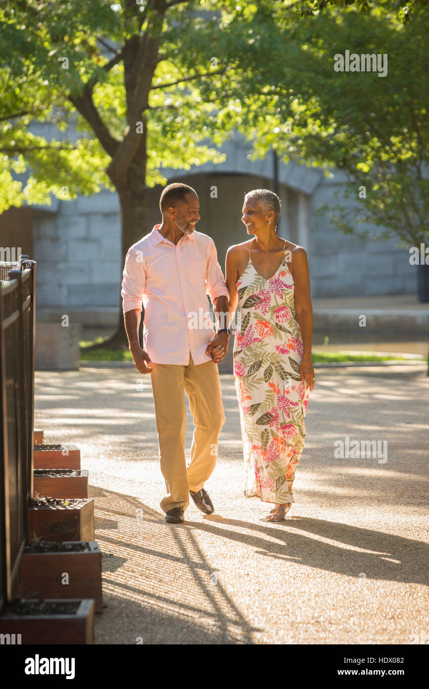 Black couple holding hands walking in park Banque D'Images