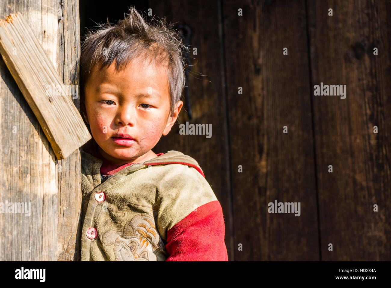 Portrait d'un petit garçon s'appuyant à une porte Banque D'Images