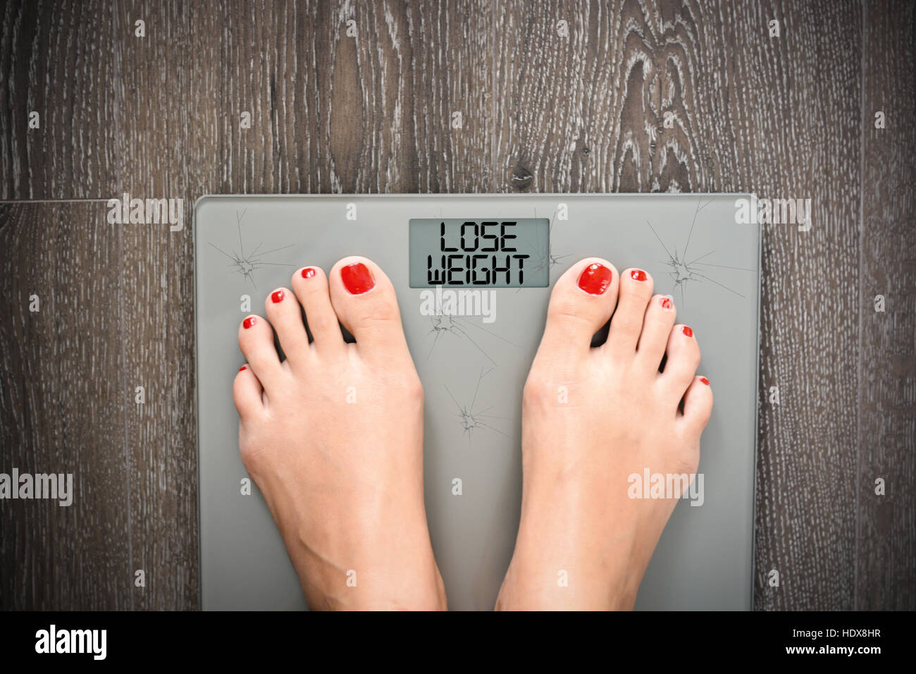 Aider à perdre kilos avec pieds femme marchant sur une échelle de poids Banque D'Images