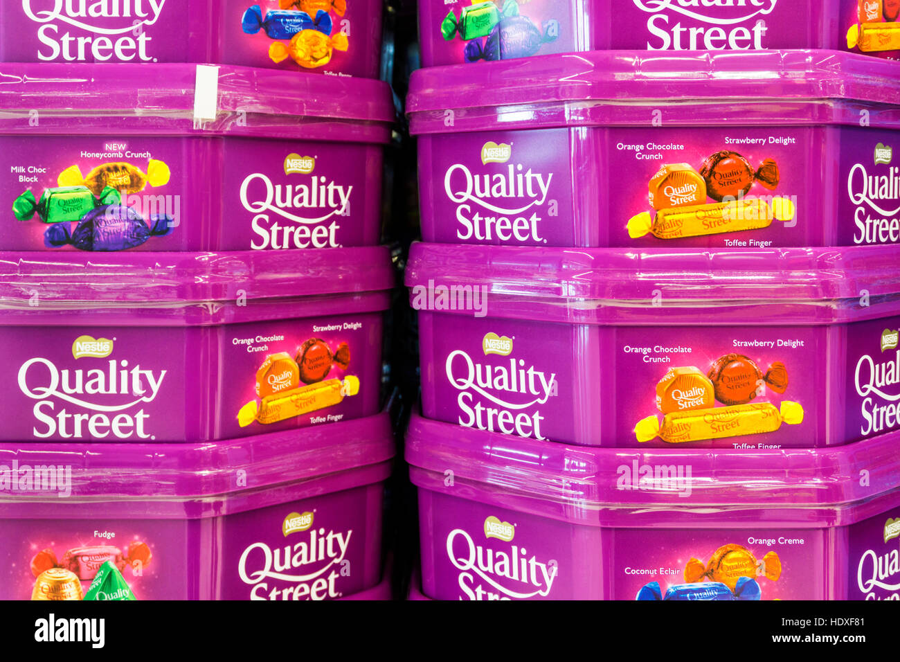 Boîtes empilées de chocolats Quality Street en attente d'être vendues pour Noël. Banque D'Images
