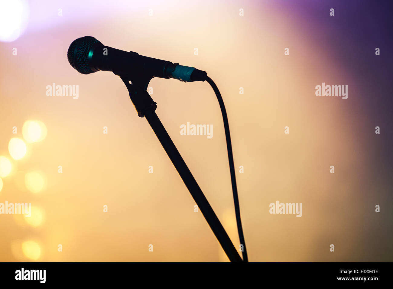 Microphone professionnel sur scène floue fond coloré Banque D'Images