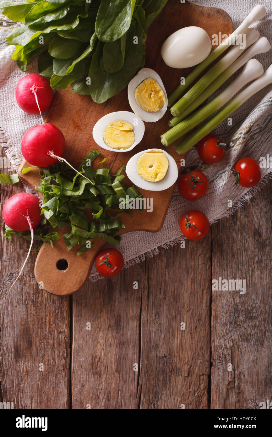 Ingrédients pour la salade : œuf, oseille, radis, tomate. vertical vue d'en haut Banque D'Images