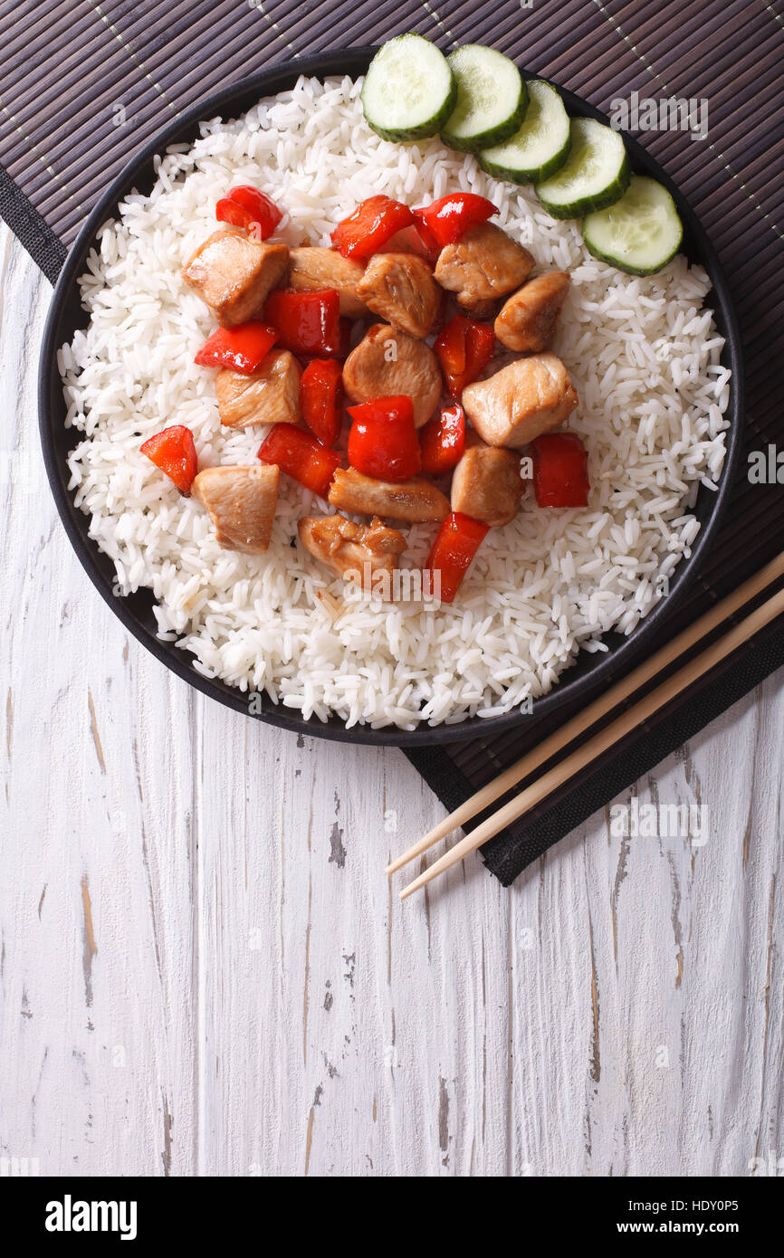 Riz avec morceaux de poulet en sauce sur une assiette. vertical vue d'en haut Banque D'Images