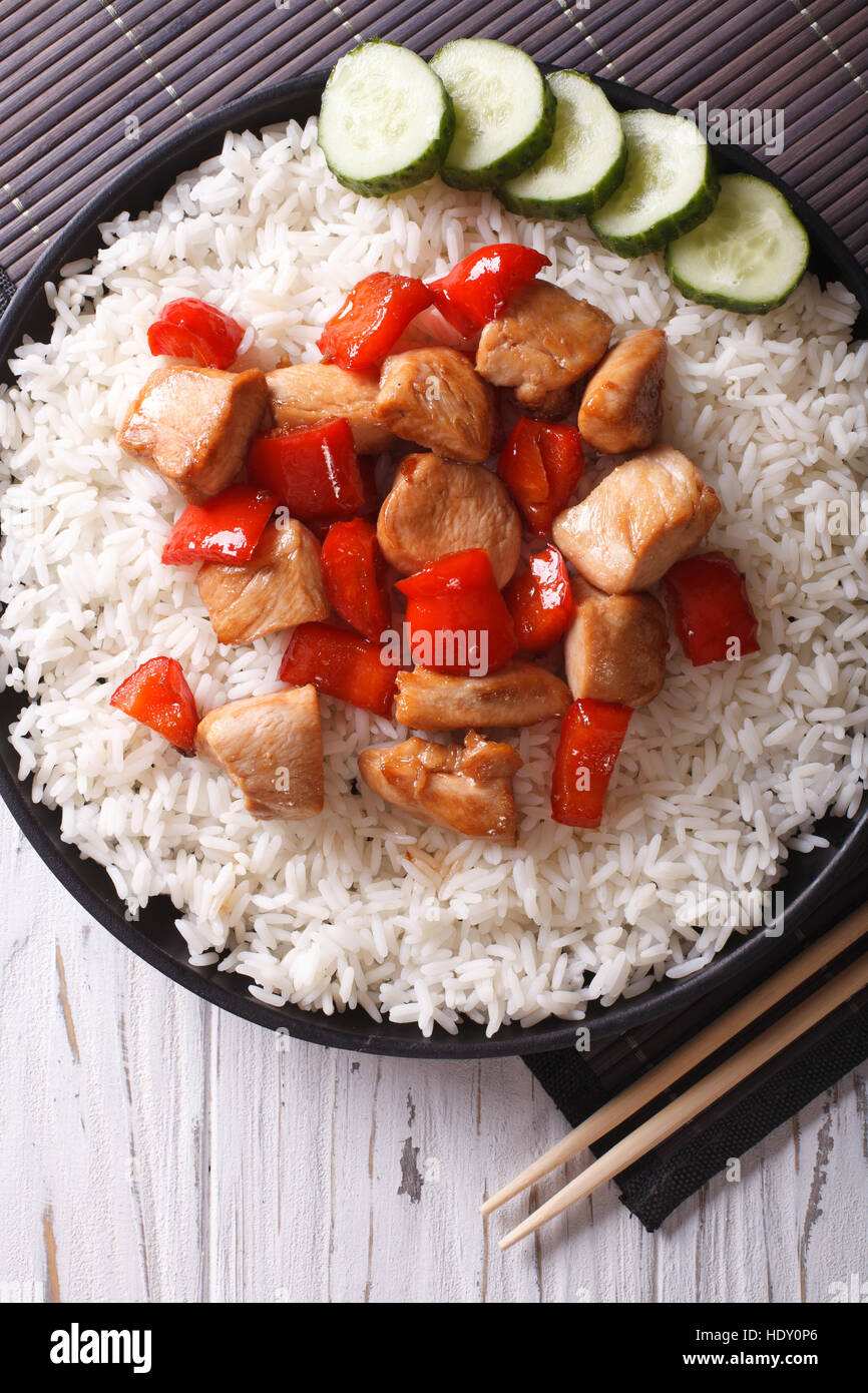 Riz avec morceaux de poulet en sauce sur une assiette close-up vertical Vue de dessus. Banque D'Images
