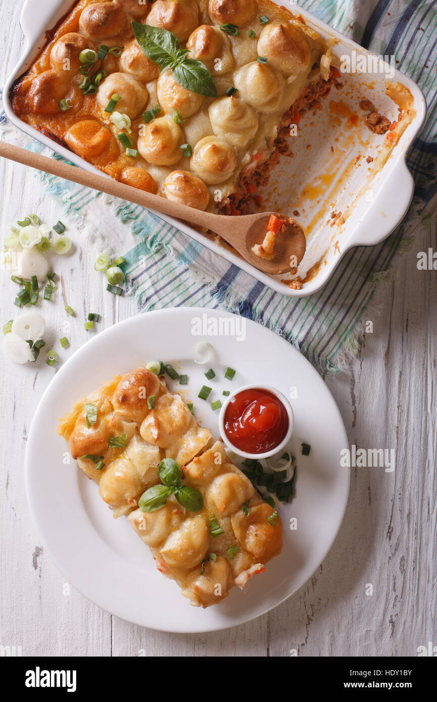 Servant de cottage pie gros plan sur une assiette blanche verticale Vue de dessus. Banque D'Images