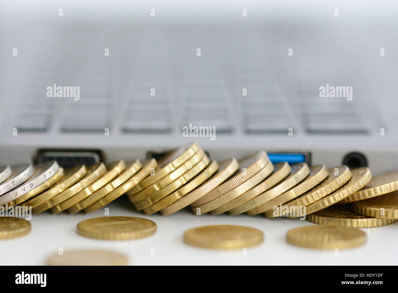 La pile ou la pile de pièces de monnaie et un clavier d'ordinateur portable Banque D'Images
